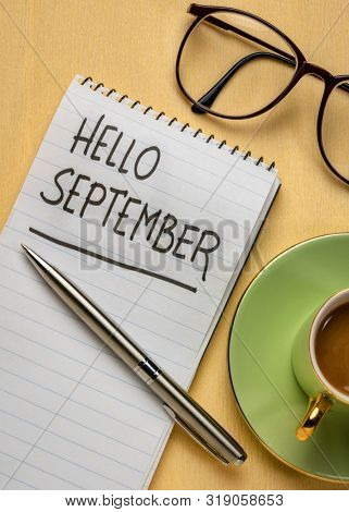 Hello September - handwriting in a spiral notebook with a cup of coffee and glasses