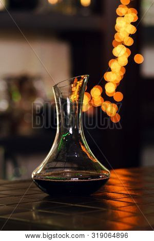 Decanter With Red Wine Stands On Bar Of Restaurant. Colorful Bokeh. Wine Tastings, Wine Tour. Warm T