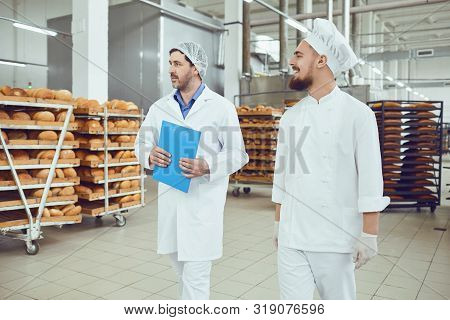 The Technologist And Baker Speak In A Bread Factory.