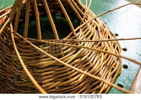 Unfinished Wickerwork Basket On Working Table. Handcraft Concept