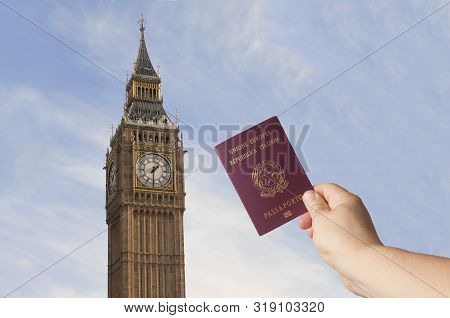 Brexit Concept: Man Hold Italian Passport In Front Of The Big Ben. Uk Announce Stop Of Fredoom Of Mo