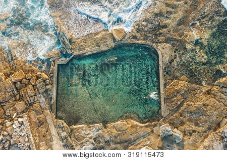 Swimmers Have A Refreshing Swim In The Coastal Rock Pool Early Morning.
