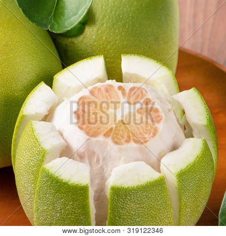 Fresh Peeled Pomelo, Grapefruit, Shaddock With Green Leaves On Dark Wooden Plank Table. Seasonal Fru