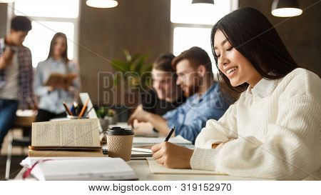 Student Girl Writing Conspect, Noticing Material To Copybook In College Library, Free Space