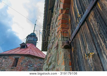Karela Fortress - Part Of The Masonry Of The Fortress Wall And An Old Door With Bolts Against A Watc