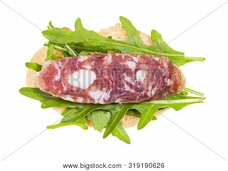 Top View Of Open Sandwich With Fresh Bread, Cured Sausage And Green Arugula Leaves Isolated On White