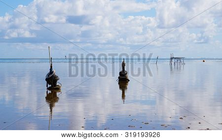 Still Water In Kaneohe Bay, Hawaii Reflects A Unique Pier At Low Tide.
