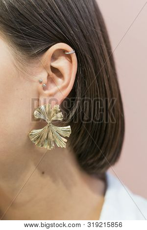 Trendy Stylish Round Gold Earrings On The Girl S Ear With Bob Haircut. Pastel Pink Background.