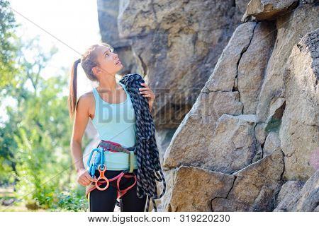Beautiful Woman Getting Ready for Climbing on the High Rock in the Mountains. Adventure and Extreme Sport Concept