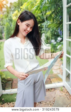 Young And Cute Asian Woman Searching Location In A Map During Holiday