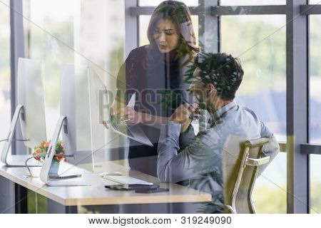 Asian Business People,  Woman Holding Notebook Computer In Her Hand , Man Checking Report From Scree