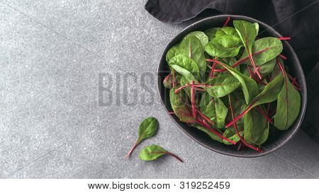 Fresh Salad Of Green Chard Leaves Or Mangold On Gray Stone Background. Flat Lay Or Top View Fresh Ba