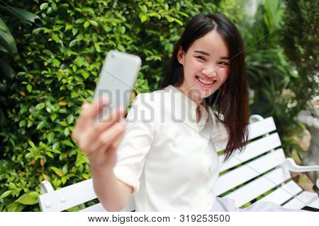 Young And Cute Asian Women Sitting And Self Portrait During Holiday