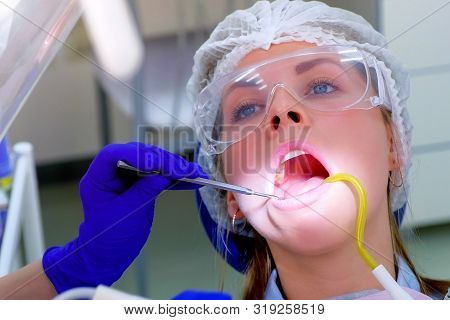 Stomatology Treatment In Clinic. Dentist Pour Water On Woman Teeth Use Saliva Ejector During Ultraso