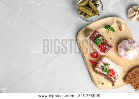 Board With Pork Fatback, Rye Bread, Garlic And Bowl Of Pickles On Stone Background, Flat Lay. Space 