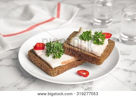 Plate With Pork Fatback Sandwiches And Shots Of Vodka On Marble Background