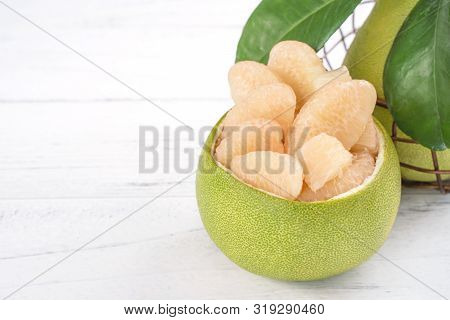 Fresh Peeled Pomelo, Grapefruit, Shaddock With Green Leaf On Bright Wooden Plank Table. Seasonal Fru