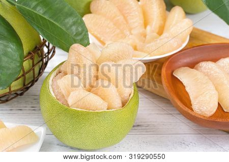 Fresh Peeled Pomelo, Grapefruit, Shaddock With Green Leaf On Bright Wooden Plank Table. Seasonal Fru