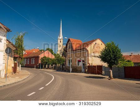 Street Of Dej City, Cluj County, Transylvania, Romania. Gothic Reformed-calvin Church On Background