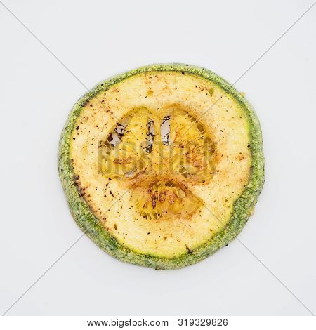 Closeup Grilled Zucchini Medallion On White Background. Pareidolia Syndrome Concept