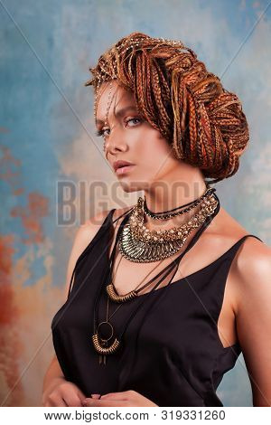 Southern Flavor. Portrait Of A Luxurious Tanned Woman, Pensive, Stylish, With An Exotic Hairstyle An