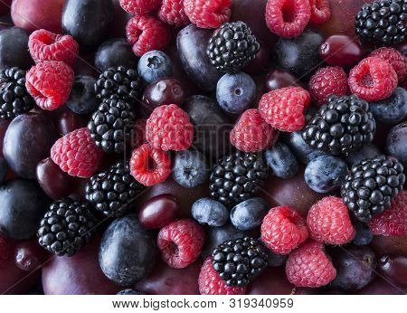 Background Of Fresh Vegetables And Fruits. Ripe Blackberries, Blueberries, Plums, Pink Grapes, Raspb