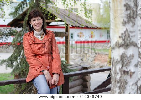 Portrait Of A Lonely Older Woman With A Beautiful Face, Smiling, Walking In The Park Waiting For The