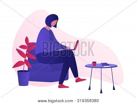 Millennial Girl Working Sitting On The Armchair And Working With Laptop. Small Table With Cup Of Cof