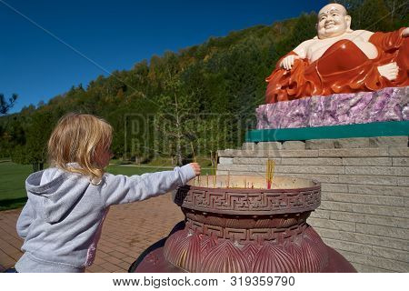 Harrington, Qc, Canada - September 23, 2018: In A Buddhist Temple, Tourists Lit Incense Sticks With 