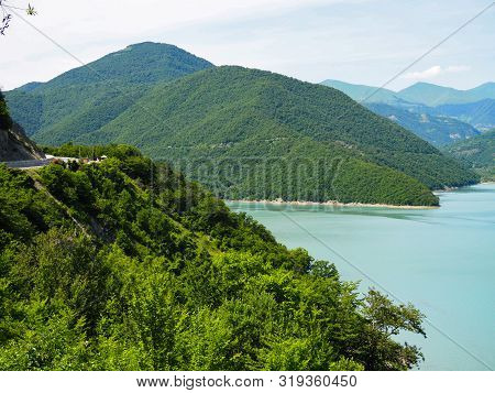 Beautiful Landscape Overlooking A Large Blue Lake In The Mountains Covered With Forest.