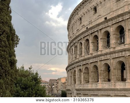 Colosseum In Rome, Italy Across Sky, Buildings And Streets