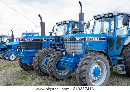 Haselbury Plucknett.somerset.united Kingdom.august 18th 2019.a Row Of Classic Ford Tractors Are Park