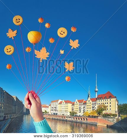 Autumn Fun In Berlin, Hand Holding Flying Balloons Made Of Cookies And Maple Leaves On The Bridge Vi