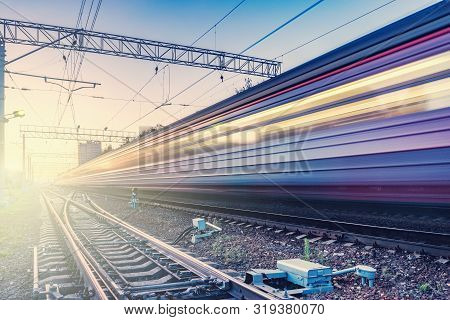 Passenger Train Moves Fast At Sunset Time.
