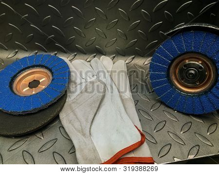 Grinding Wheel With Gloves On Metal Background