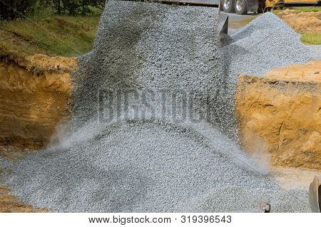 Excavator Extracting Backfill Of Foundation Stone For A New Home Construction