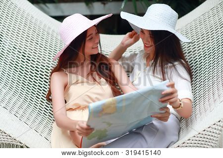 Young And Cute Asian Women Lying In A Hammock And Searching Location In A Map During Holiday