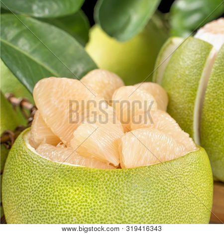 Fresh Peeled Pomelo, Grapefruit, Shaddock With Green Leaf On Bright Wooden Plank Table. Seasonal Fru