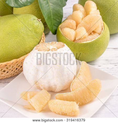 Fresh Peeled Pomelo, Grapefruit, Shaddock With Green Leaf On Bright Wooden Plank Table. Seasonal Fru