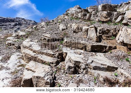 Rocks In The Mountains Against The Blue Sky.
