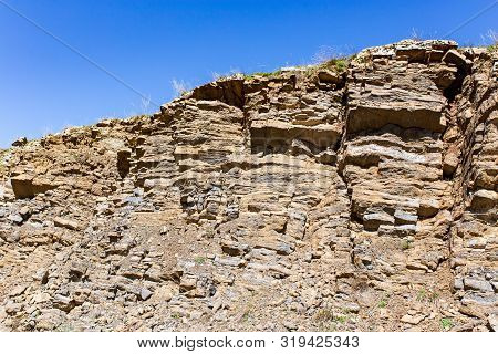 Rocks In The Mountains Against The Blue Sky.