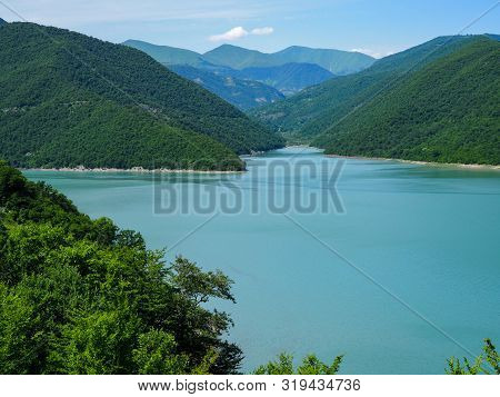 Beautiful Landscape Overlooking A Large Blue Lake In The Mountains Covered With Forest
