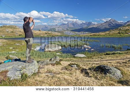 Saint-sorlin, France, August 9, 2019 : Photographer Shoots A Beautiful Landscape On A Mountain Lake 