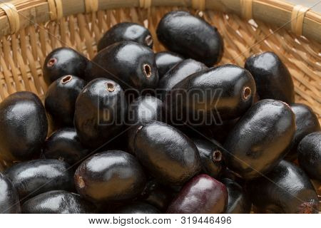 Whole fresh Jamun berries in a basket