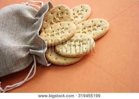Reusable Canvas Bag And Multicereal Biscuits On Brown Background . Care For The Environment And Heal