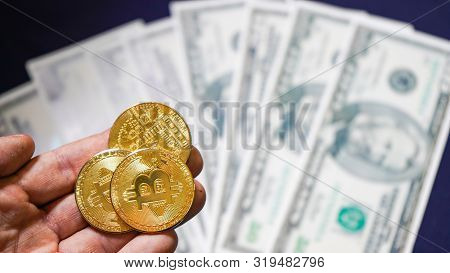 Bitcoins On The Background Of Dollars. Golden Bitcoins. New Virtual Money. Symbolic Coins Of Bitcoin