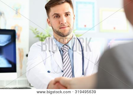 Portrait Of Smiling Doc Saying Hello Or Goodbye To Patient. Physician Wearing White Uniform And Stet