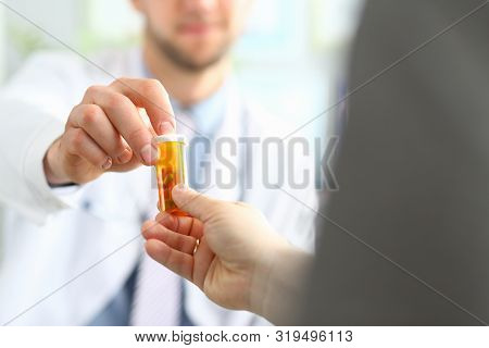 Focus On Male Hand Of Doctor Giving Bottle With Pills To Visitor. Doc Making Recommendation To Sick 