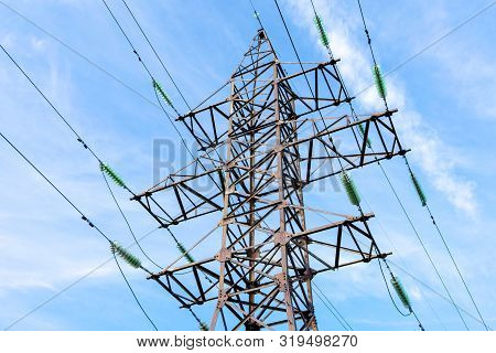 High Voltage Tower Against The Blue Sky. Electric Tower And Cables. Electrical Linear Insulator.