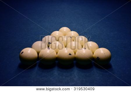 Ivory White Billiard Balls On A Blue Pool Table Close Up. Triangle Or Pyramid On The Table.